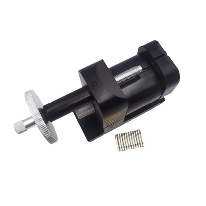 Alloy steel watch strap removal tool for watch repair on a workbench.