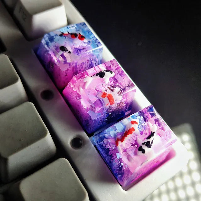 Close-up of a custom resin keycap featuring a detailed blue and orange koi fish scene, designed for Cherry MX mechanical keyboards.