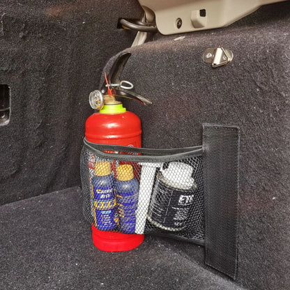 A stretchy polyester car boot storage net in a vehicle trunk, holding loose items securely.
