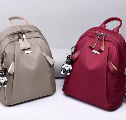 Medium square rucksack in Oxford cloth with two straps and a soft handle, shown in wine red.