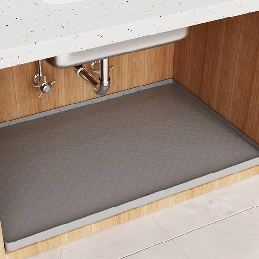 Grey silicone sink mat measuring 864mm by 558mm protecting kitchen cabinet from water damage