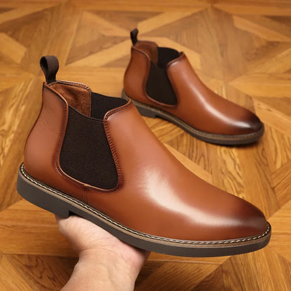 Black and brown formal pointed-toe leather boots with a square heel on a rubber sole.