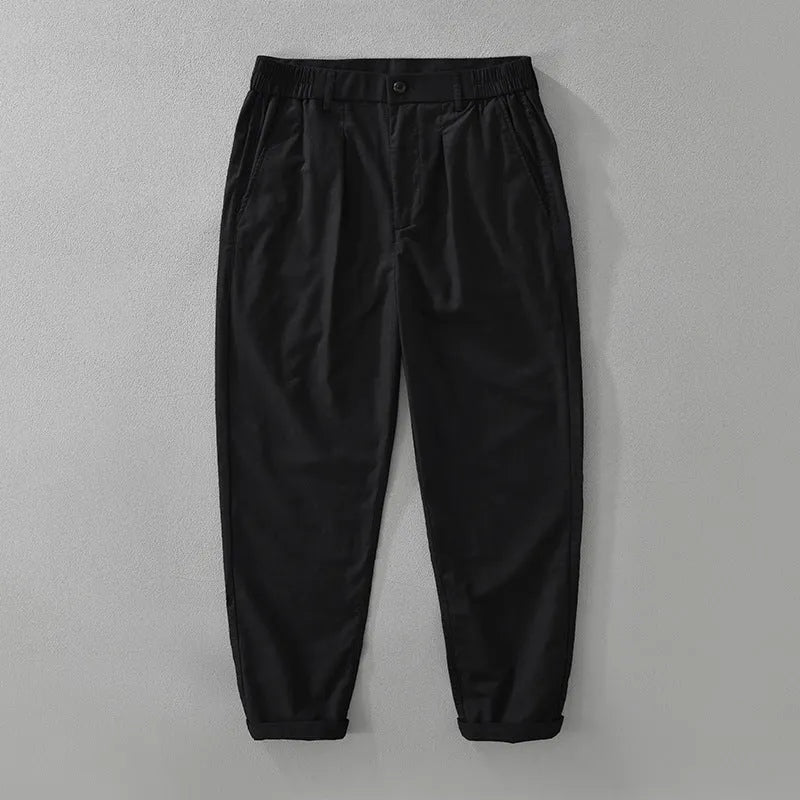 Man wearing loose beige straight-leg cotton linen trousers in a casual setting