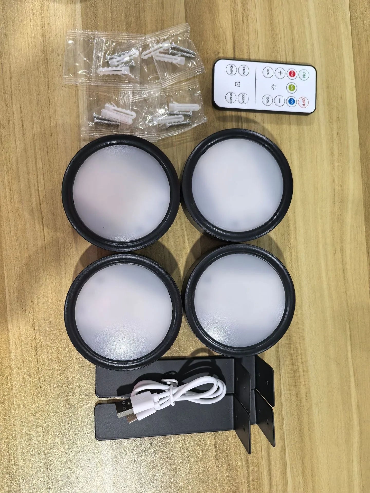 Black magnetic LED painting lamp with remote control on a white wall.