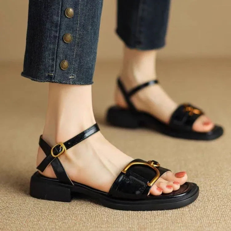 Women's black leather sandals with a thick rubber sole and button fastening on a round toe.