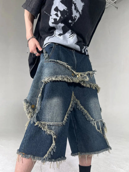 Blue men's loose-fit denim shorts with a frayed hem and a white five-pointed star patch on the leg.