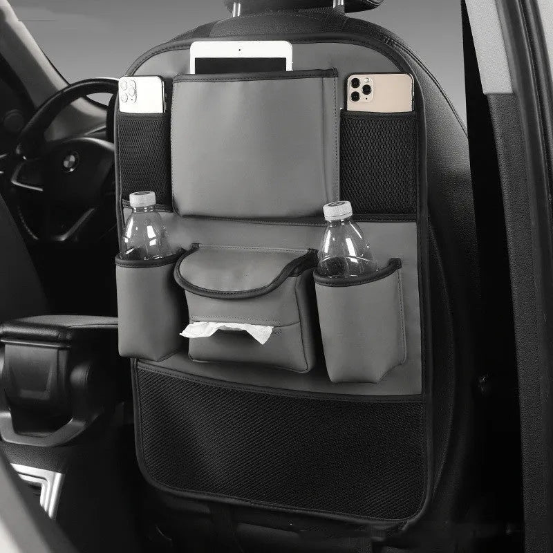 Genuine leather car seat back storage bag in brown, mounted on a grey car seat headrest.