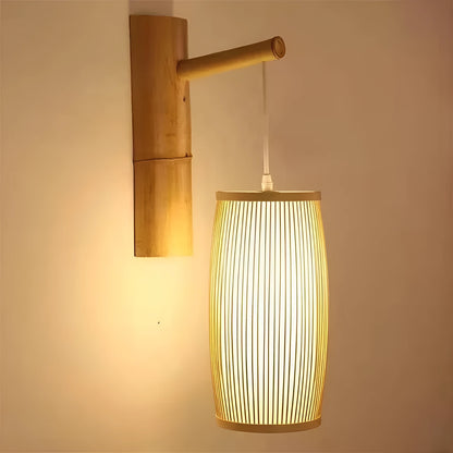 Cylindrical natural bamboo plaited lamp shade with open weave, shown on a wooden table.