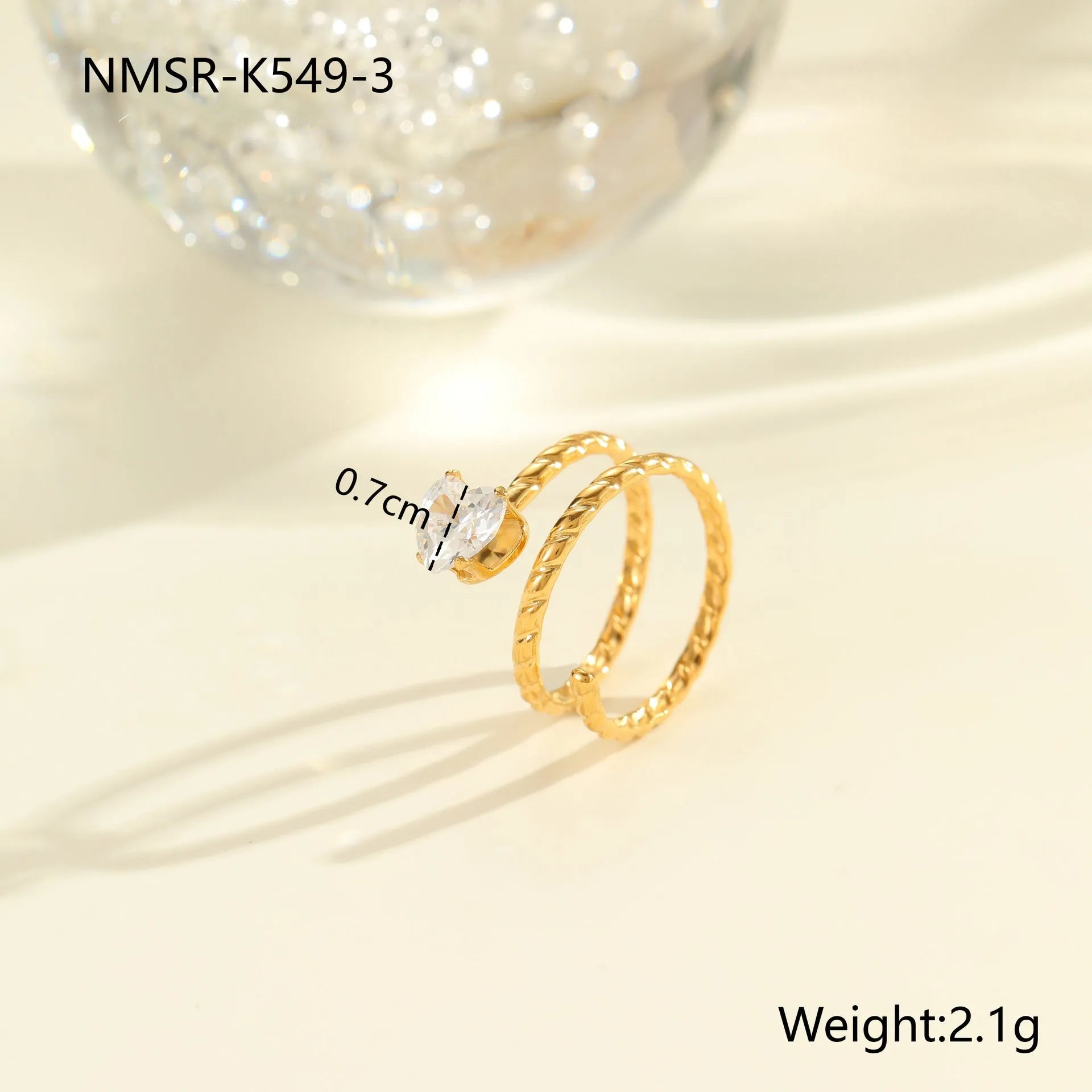 Gold electroplated stainless steel open mouth ring with geometric shapes and zircon inlay on a heart drop.