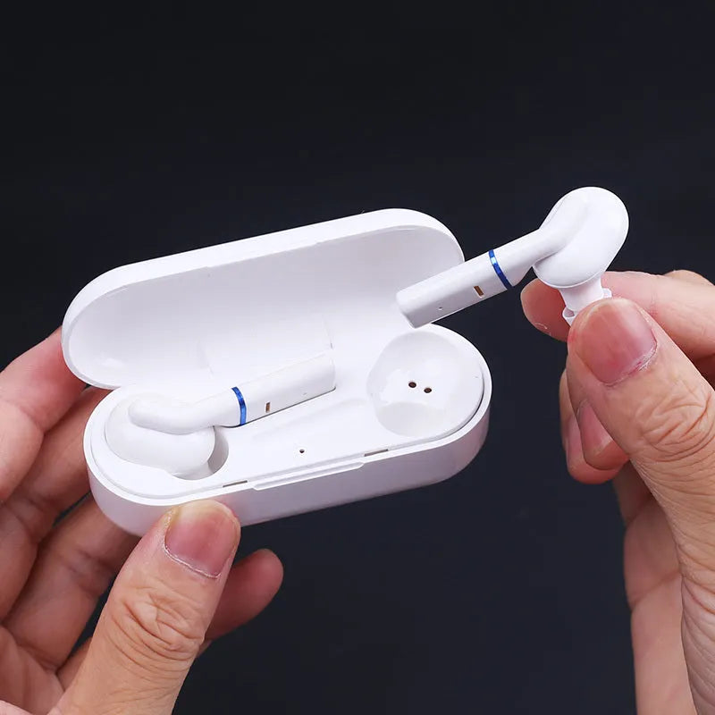 VV1 black and white Bluetooth earphones with a compact charging case on a table.