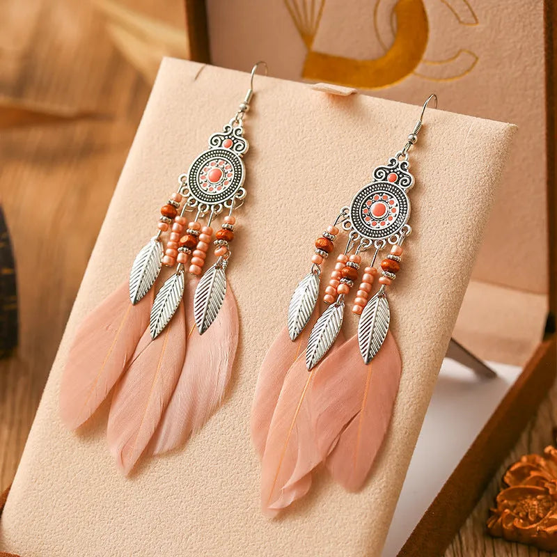 Bohemian feather leaf pattern alloy earrings in round drop shape on a colour selection background.
