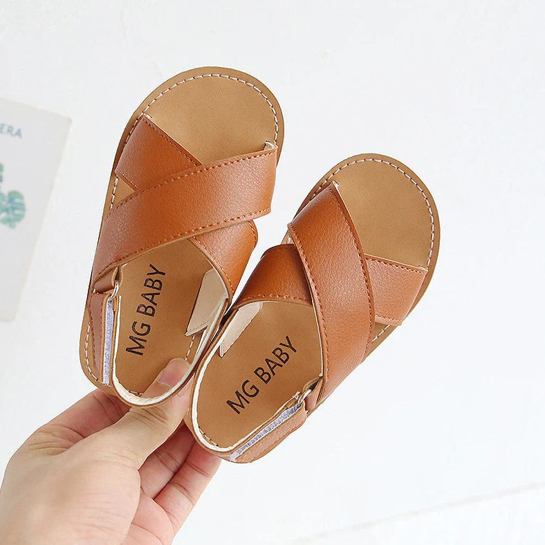 Children's black cross-strap sandals with adjustable Velcro fastening showing size range 21-30