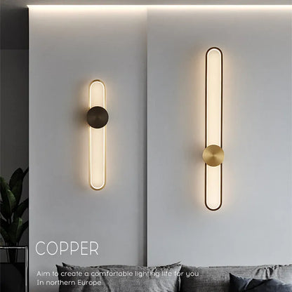 Round black iron wall sconce with integrated LED light glowing on a modern grey wall