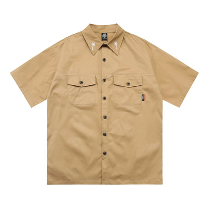 Man wearing a black cotton blend half-sleeve loose fit work shirt with embroidered detail.
