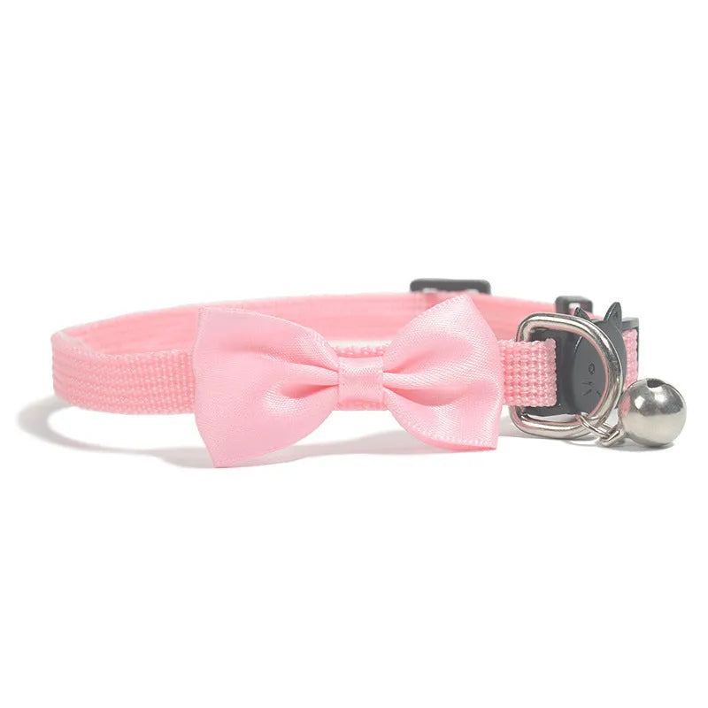 Striped nylon cat collar with decorative bow and bell in multiple colour options on a white background.