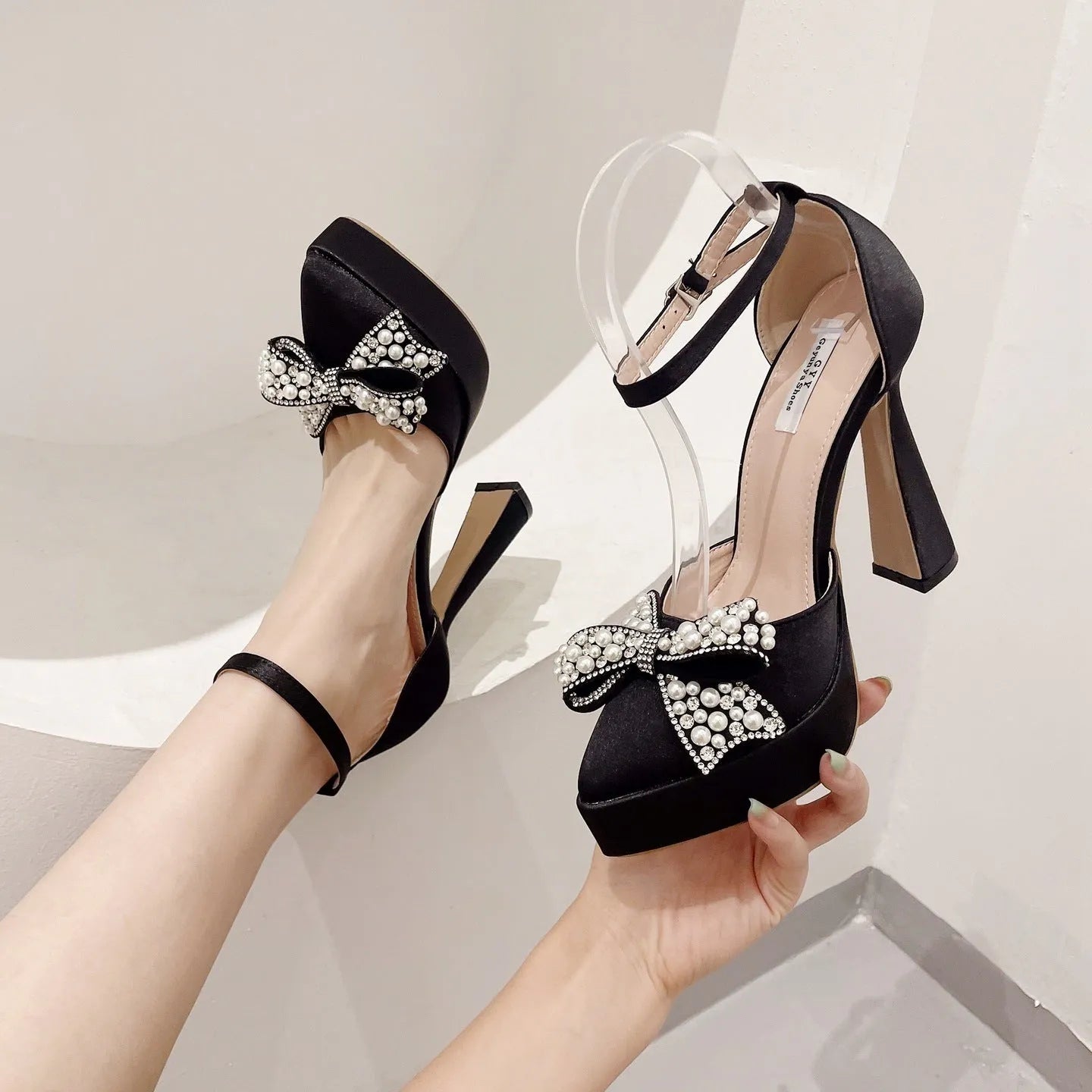 Women's black satin pointed-toe sandals with a bow detail and loop strap