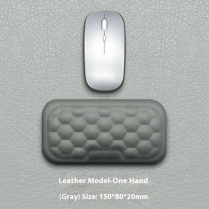 Black and grey memory foam mouse wrist rests with cloth and leather-style covers on a desk.