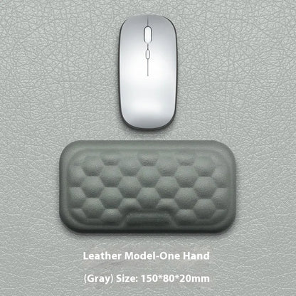 Black and grey memory foam mouse wrist rests with cloth and leather-style covers on a desk.