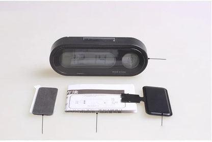 Black electronic car clock thermometer with LED display showing time and temperature, mounted on adjustable bracket