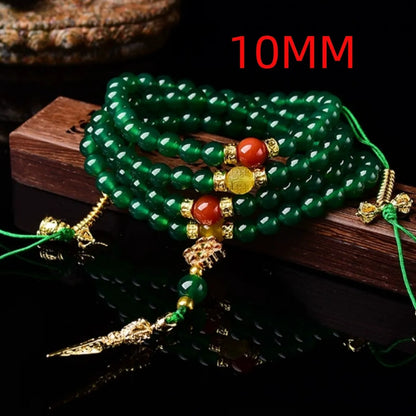 Close-up of a multi-strand green agate bracelet with natural stones on a wrist.