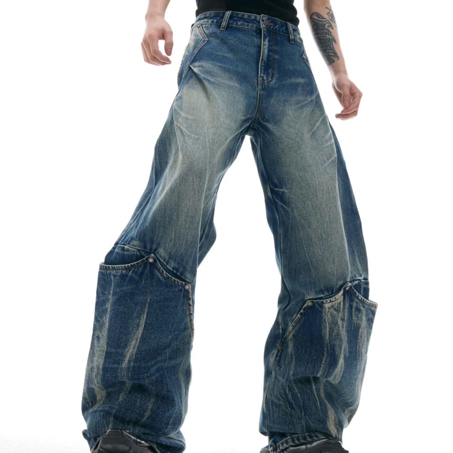 Men's verdant blue jeans with washed burst pattern and curved knife design, showing loose fit and retro style.