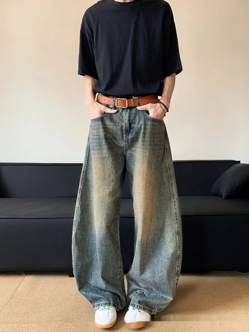 Man wearing retro blue distressed slim-fit jeans with a wide-leg cut.