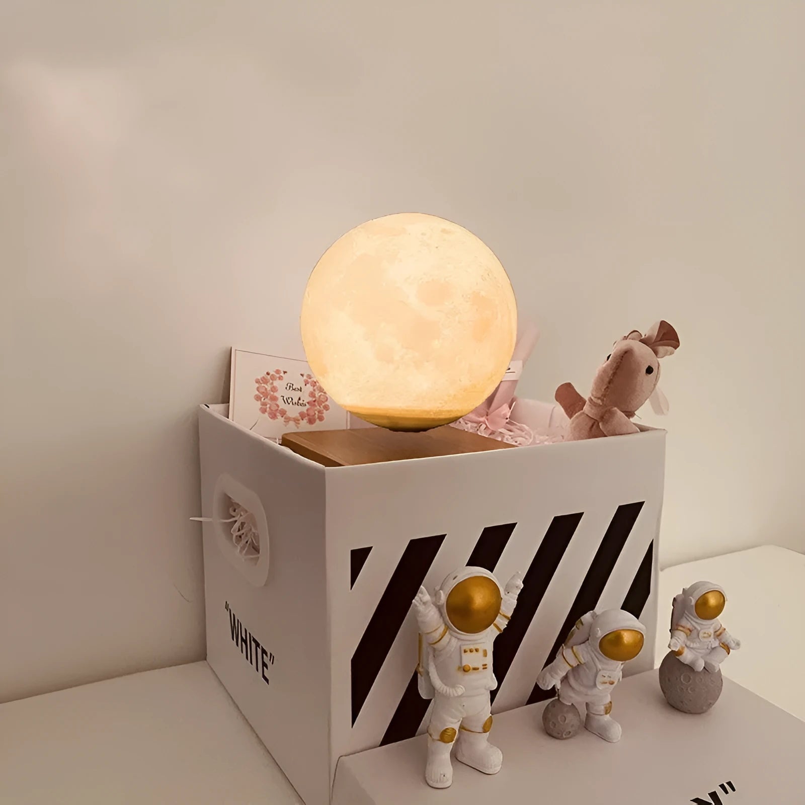 Maglev floating night light with glowing moon and planet designs on a table.