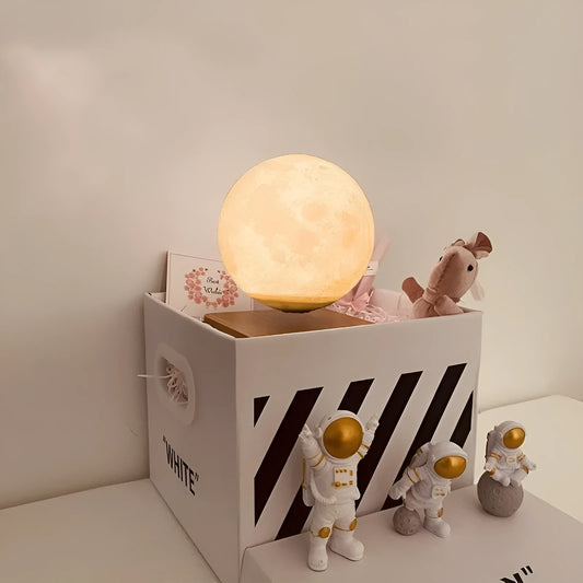 Maglev floating night light with glowing moon and planet designs on a table.