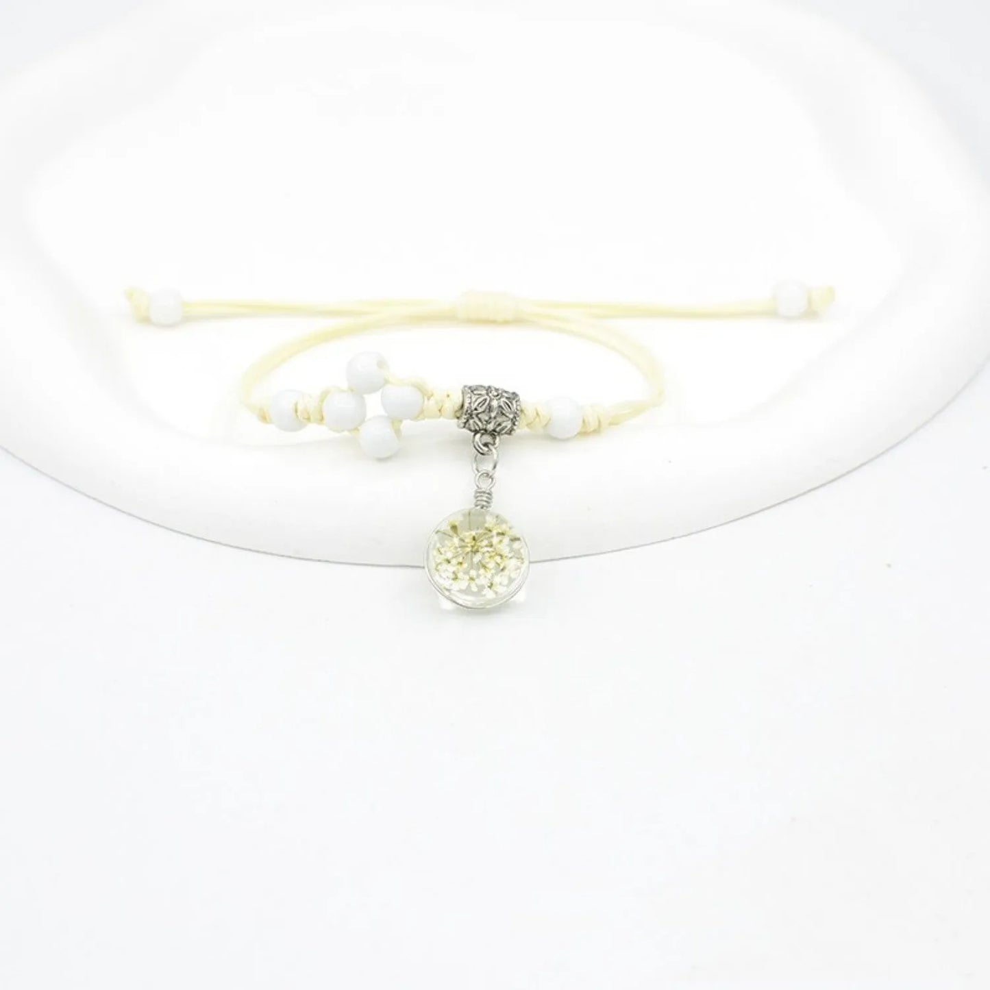Hand-woven glass bracelet with large 1.4 cm beads containing real dried flowers, shown in blue.