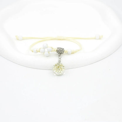 Hand-woven glass bracelet with large 1.4 cm beads containing real dried flowers, shown in blue.