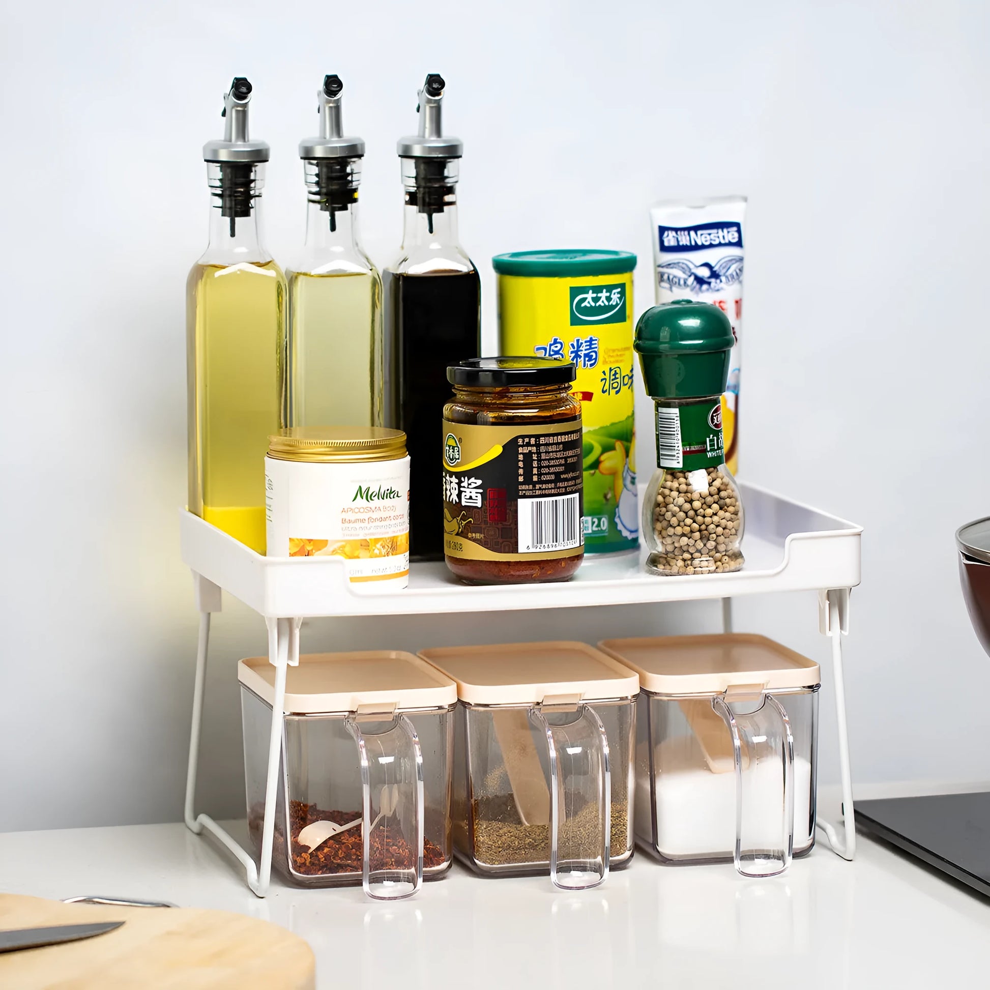 Transparent and white plastic kitchen supplies rack with multiple compartments for drawer and shelf organisation