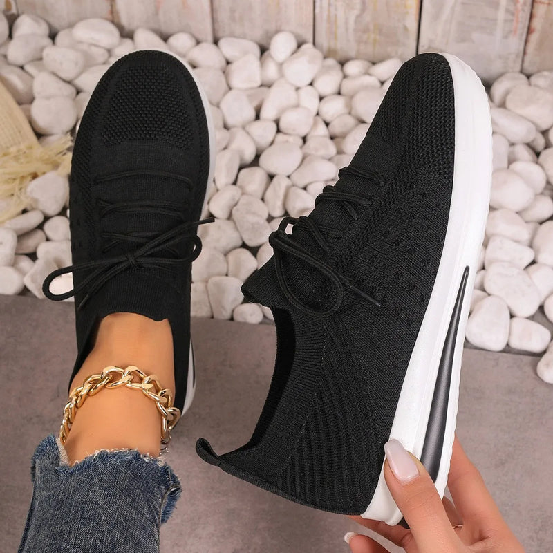 Women's casual sneakers with fly-knit textile uppers in low-top round-toe design, featuring breathable construction and front lace-up closure, available in red, black, and blue colours across sizes 36 to 43.