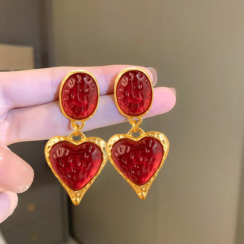 A pair of silver-tone stud earrings with a textured pleated oval love heart shape in various colour options.