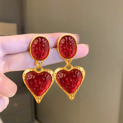 A pair of silver-tone stud earrings with a textured pleated oval love heart shape in various colour options.