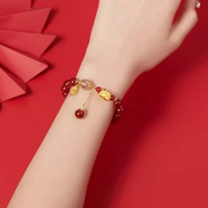 Women's Chinese style bracelet with Hetian jade, red agate beads, and a dragon design on gold and silver.