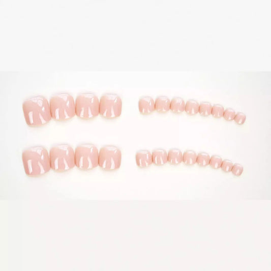 Fashion Personality toe nail stickers in skin colour with design, next to tube of adhesive glue on a flat surface.
