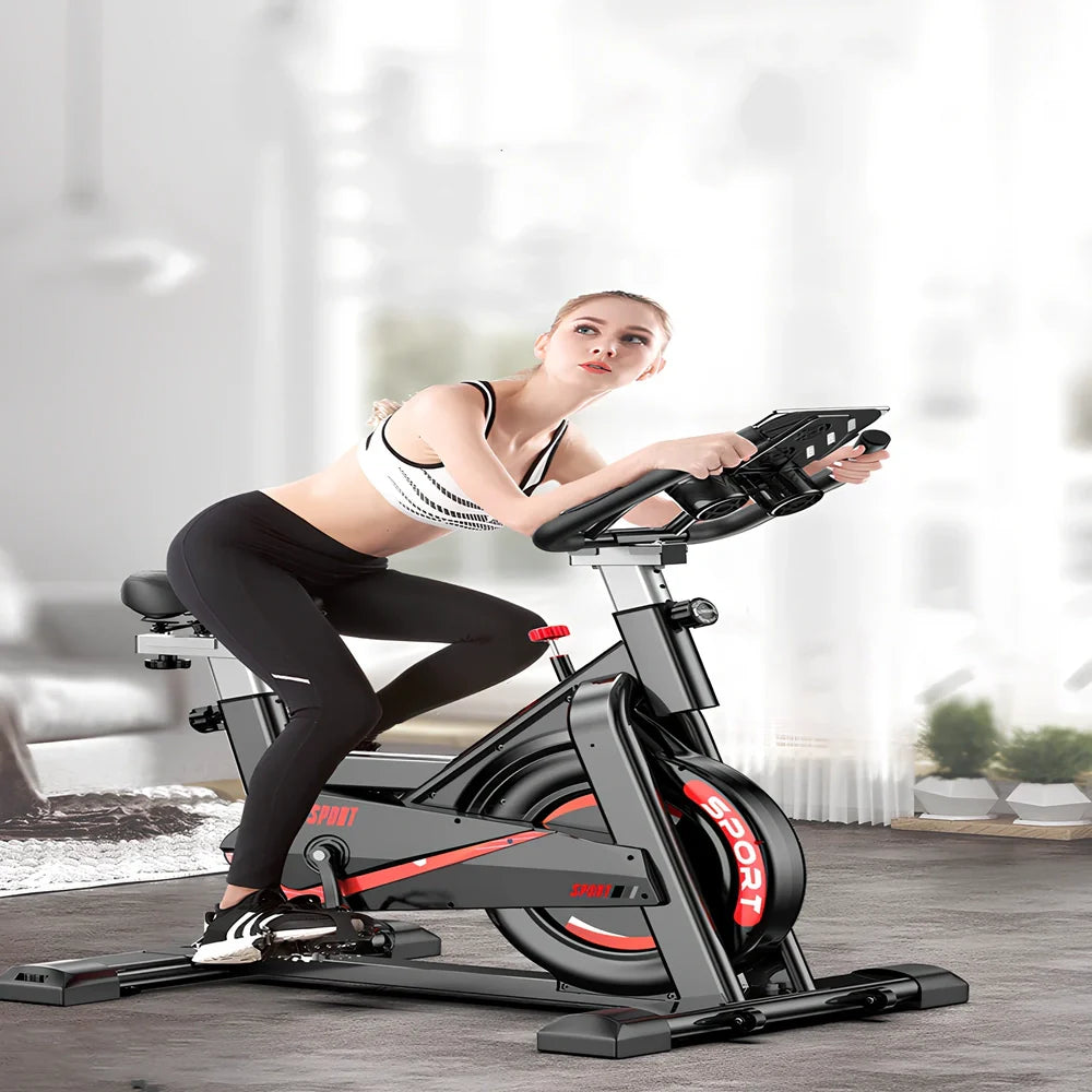 Black upright spinning bike with infinite resistance display for silent home fitness tracking distance and calories
