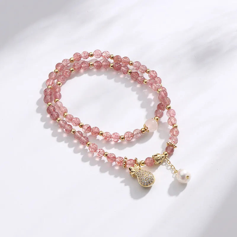 Women's geometric strawberry quartz crystal bracelet with a silver wallet money charm.