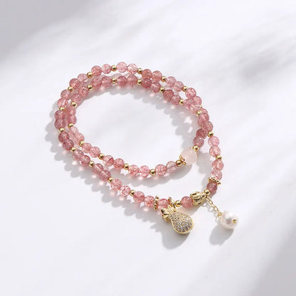 Women's geometric strawberry quartz crystal bracelet with a silver wallet money charm.