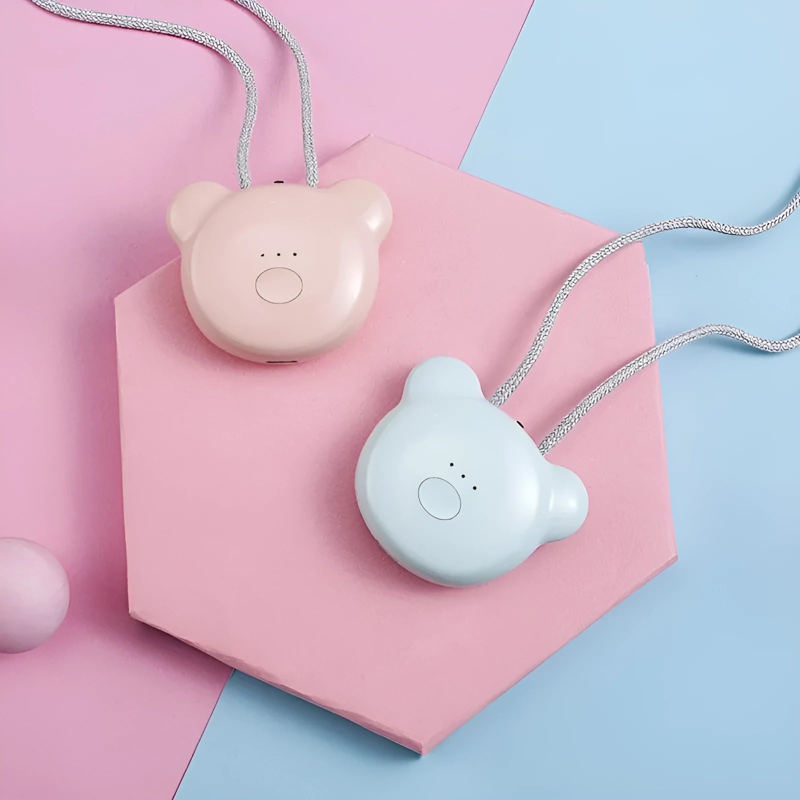 Pink wearable USB air purifier necklace on a table with USB cable, showing compact size.