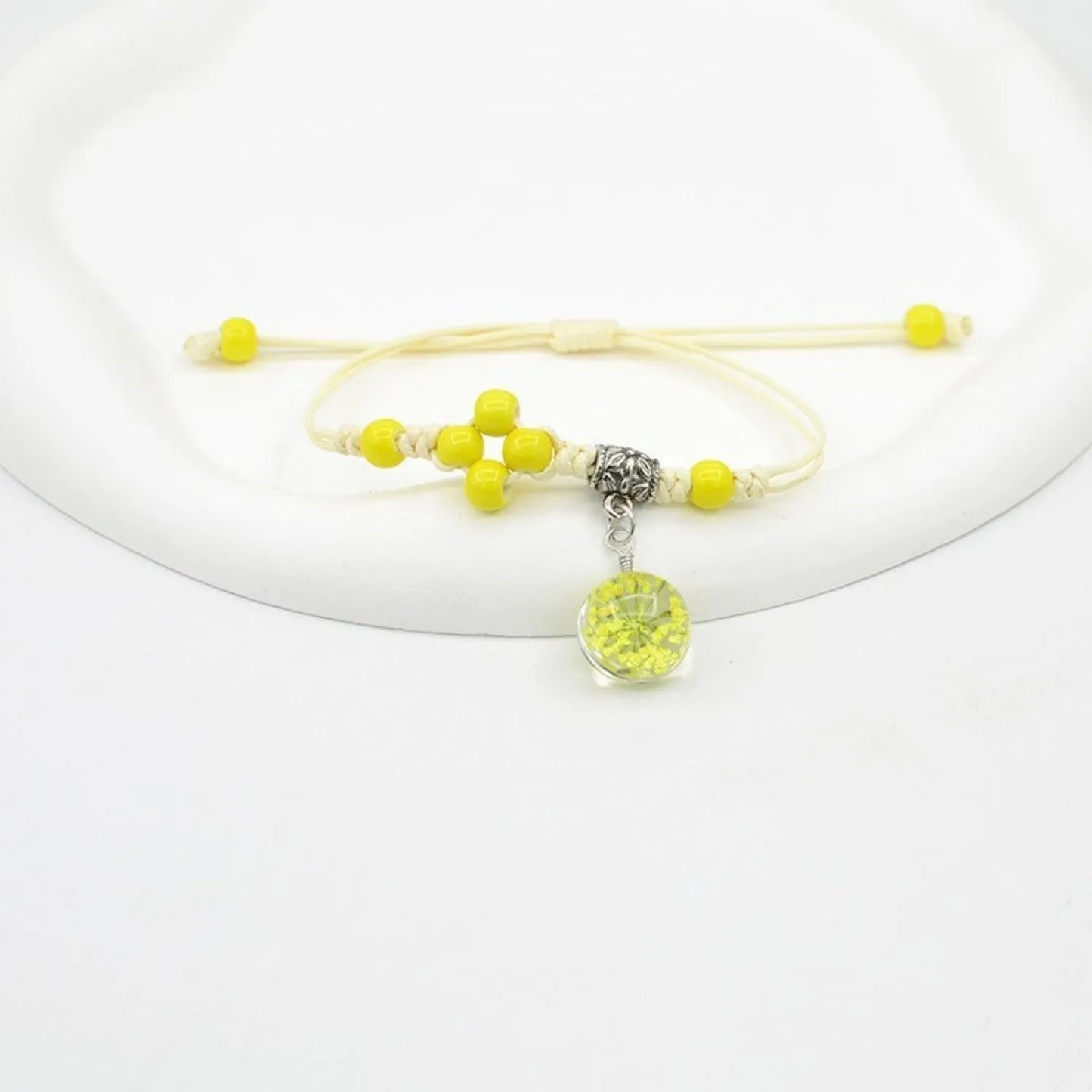 Hand-woven glass bracelet with large 1.4 cm beads containing real dried flowers, shown in blue.