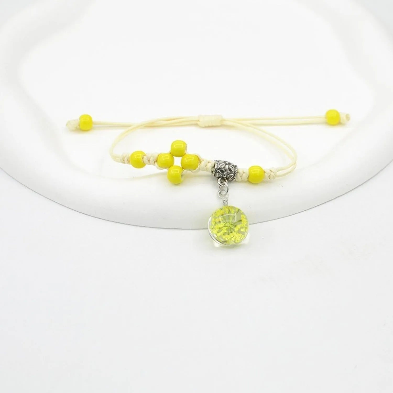 Hand-woven glass bracelet with large 1.4 cm beads containing real dried flowers, shown in blue.