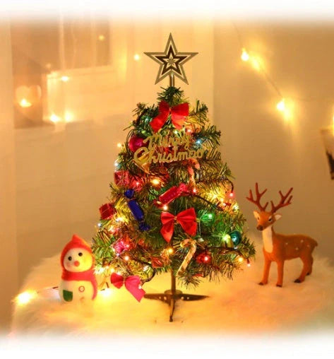 Mini Christmas tree with multi-color LED lights and festive accessories on a desktop