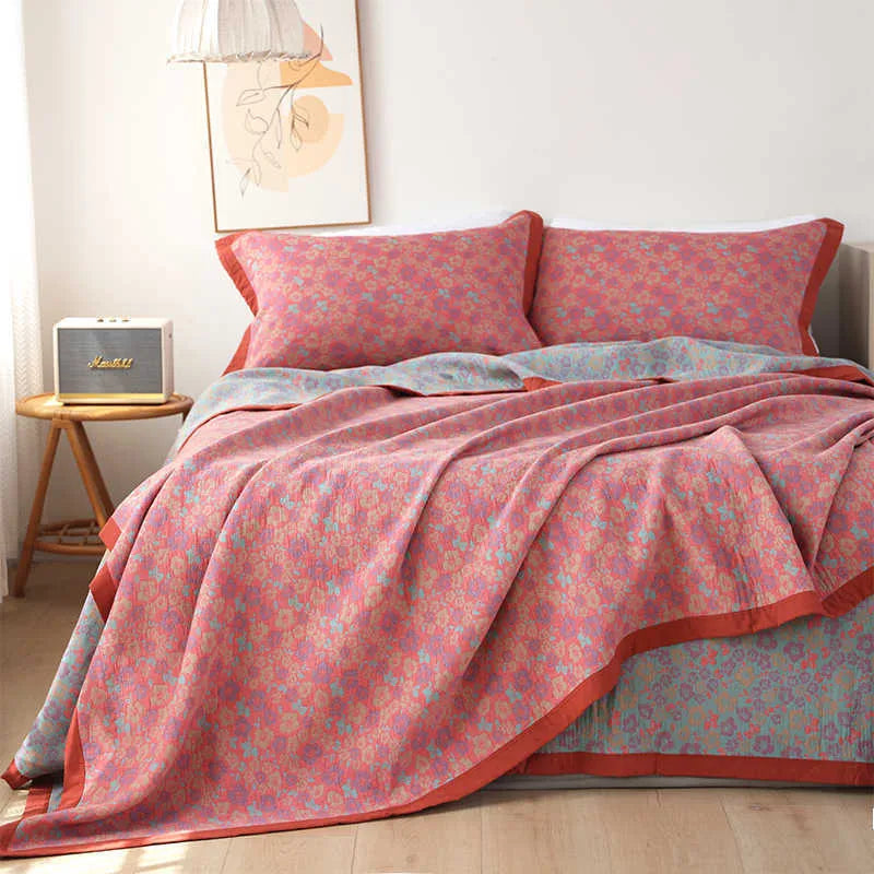 Three-piece cotton gauze bed set with floral print, showing blanket and pillowcases on a bed.