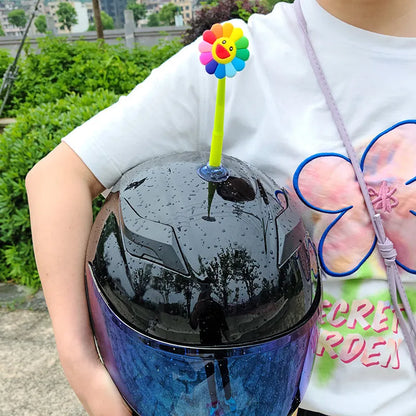 Yellow silicone sunflower decoration with suction cup attached to bicycle helmet, showing swinging motion