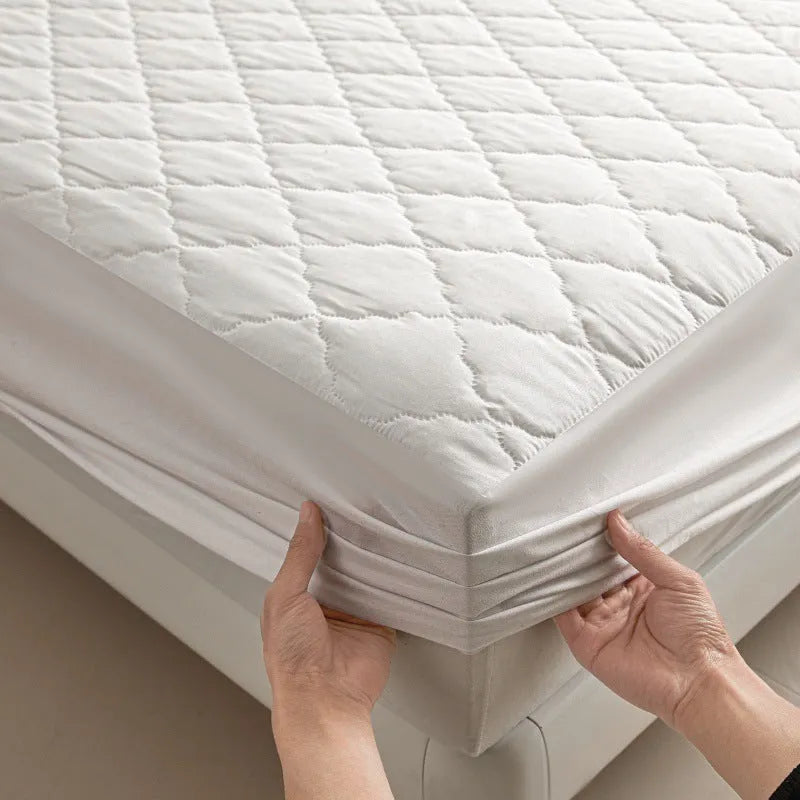 Diamond lattice quilted bamboo fibre mattress protector set in solid colour on a bed.