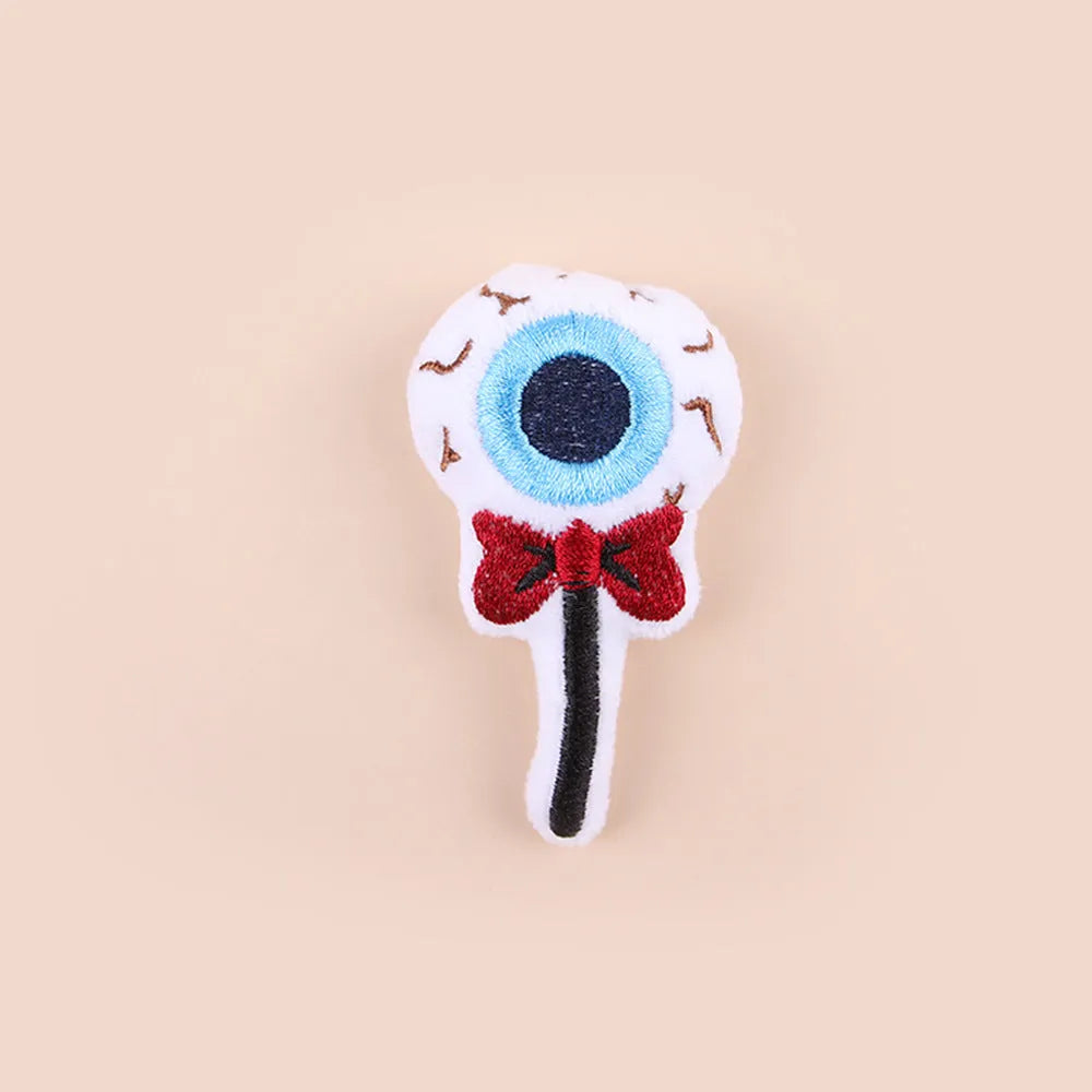 Plush cat teaser wand with candy, eyes, and skull heads on a 40cm string next to a wand handle.