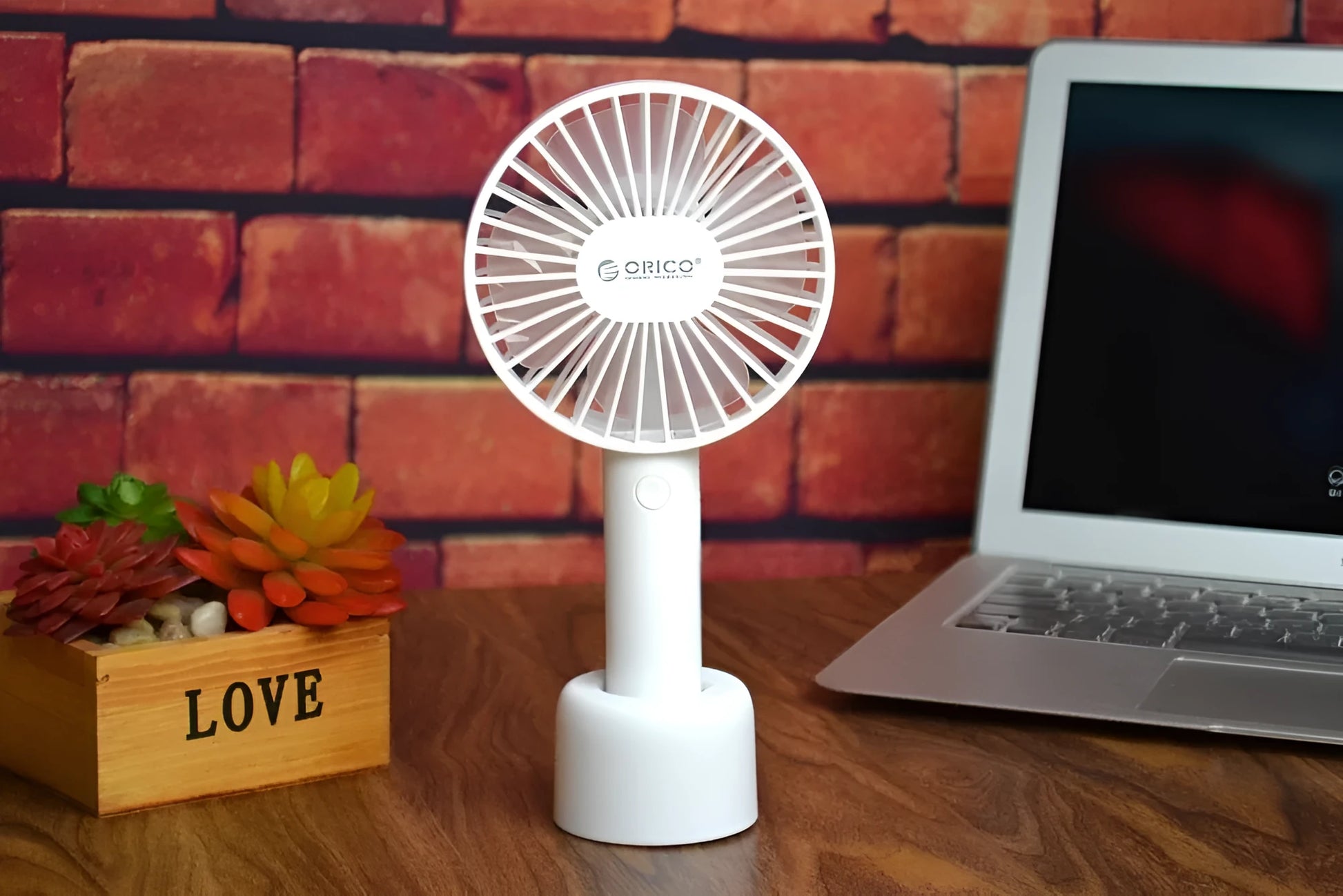White ORICO FH1 portable USB desk fan with rechargeable battery on a wooden desk