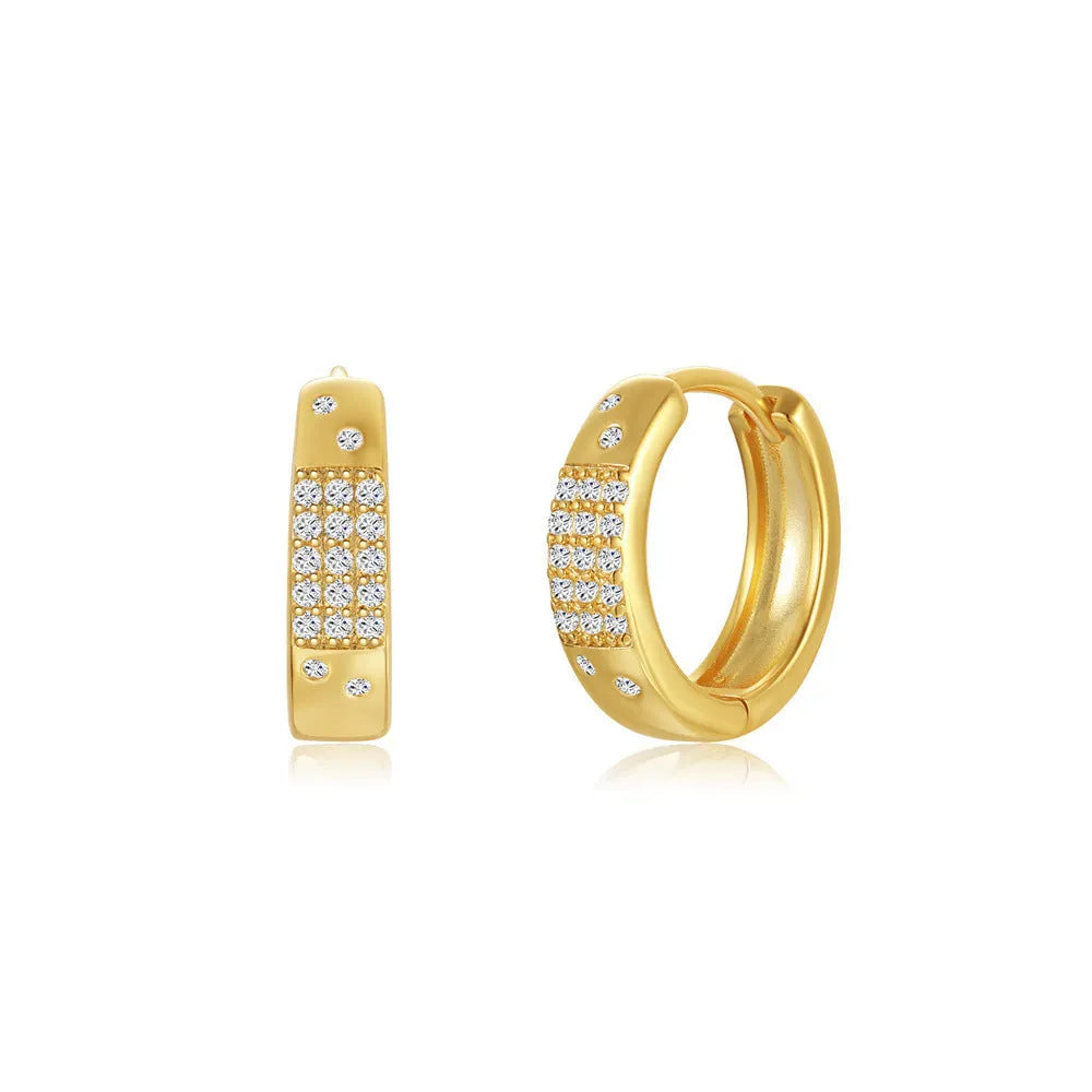 A pair of golden geometric clip-on earrings with a round design element on a white background.