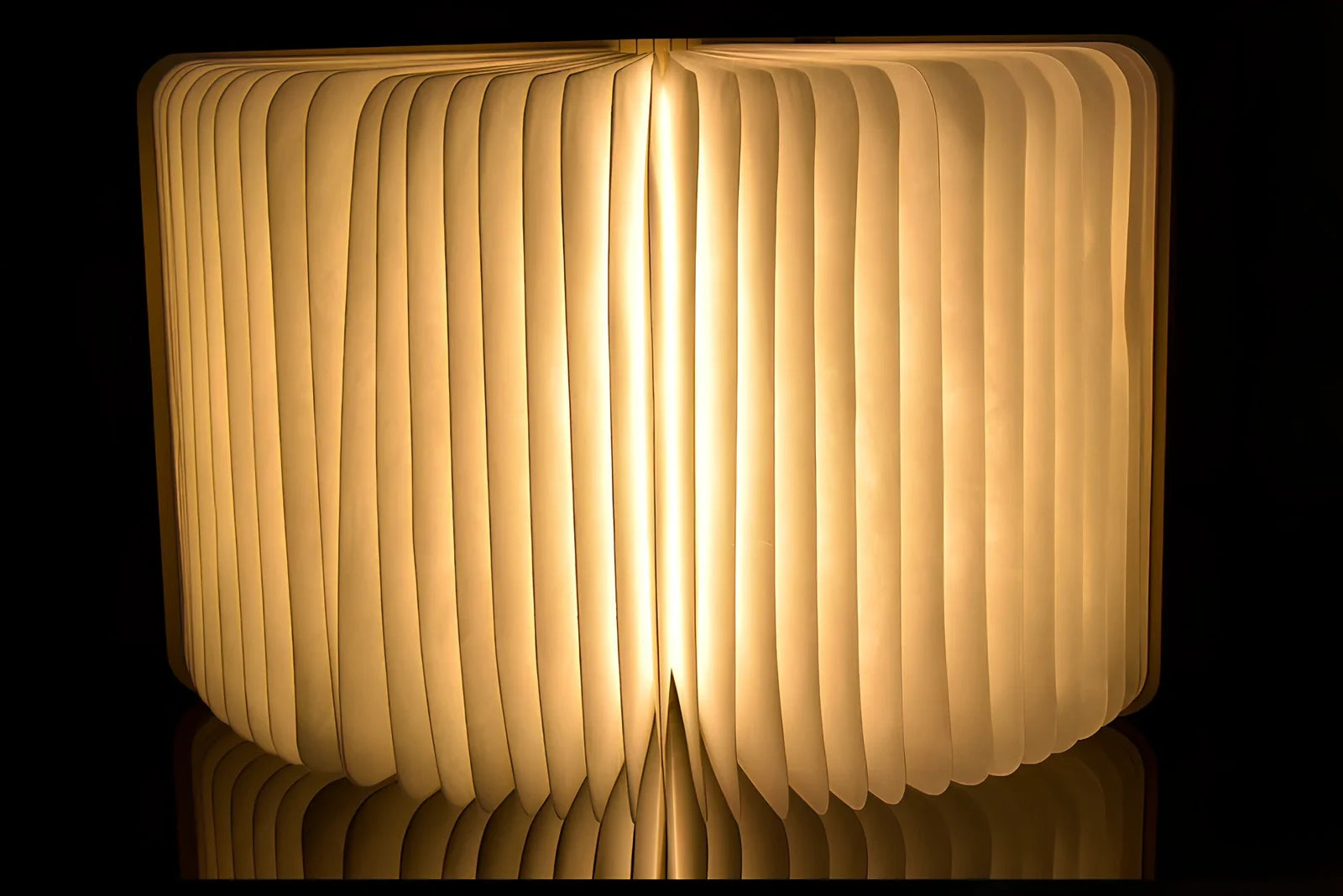 LED book lamp with wooden cover open at angle showing illuminated pages and USB cable